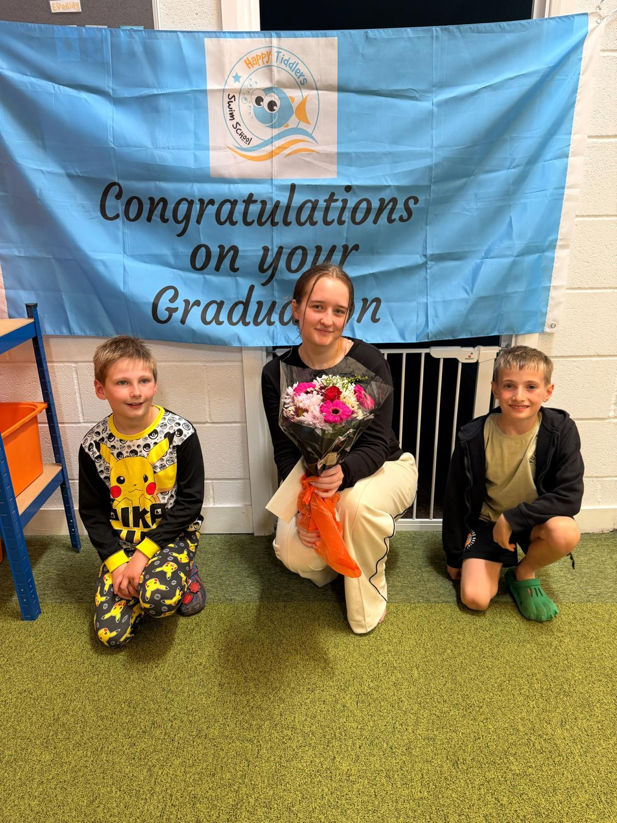 Happy Tiddlers swimmer celebrating her graduation with siblings