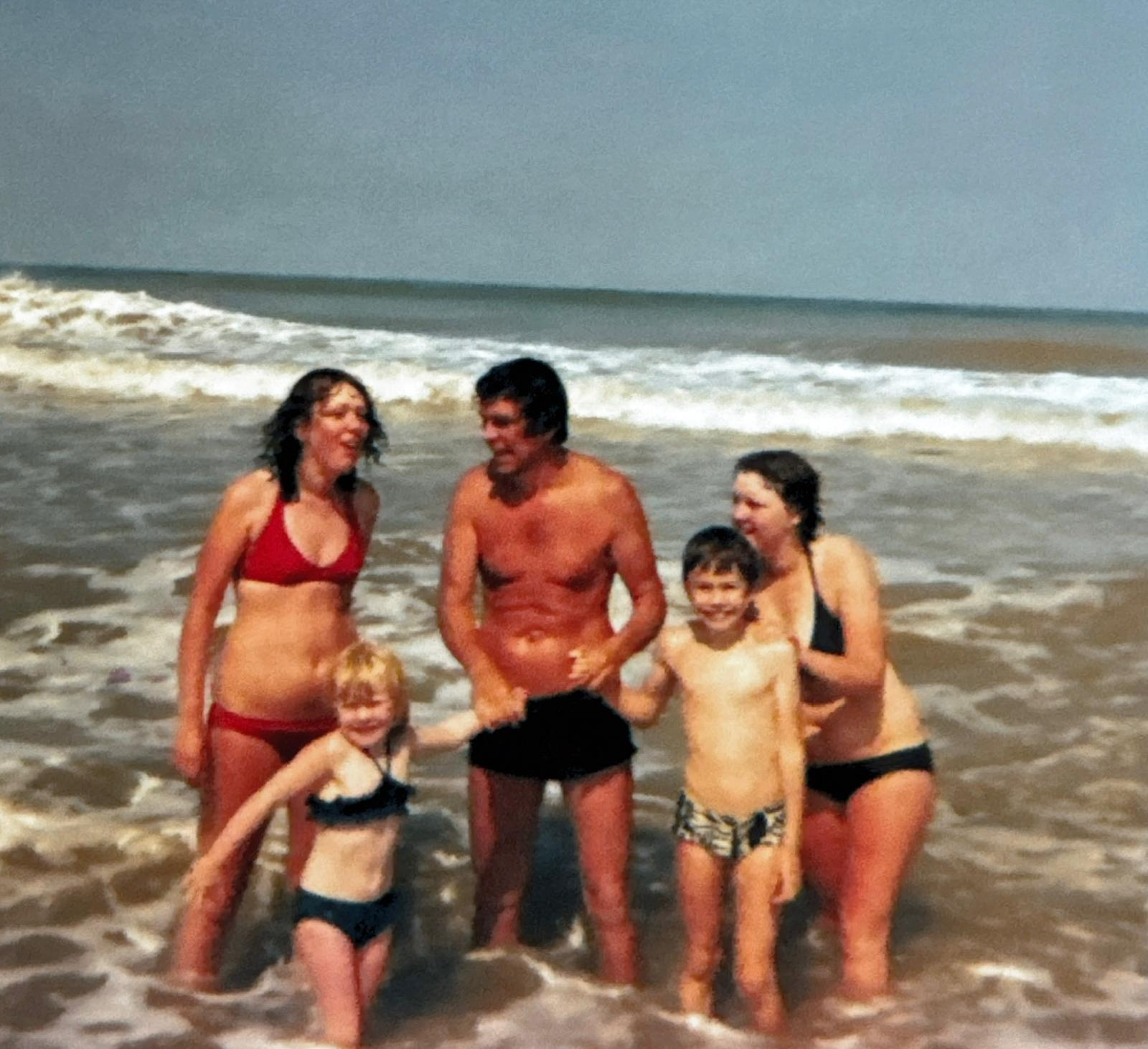 A family enjoying the sea together on a summer beach holiday